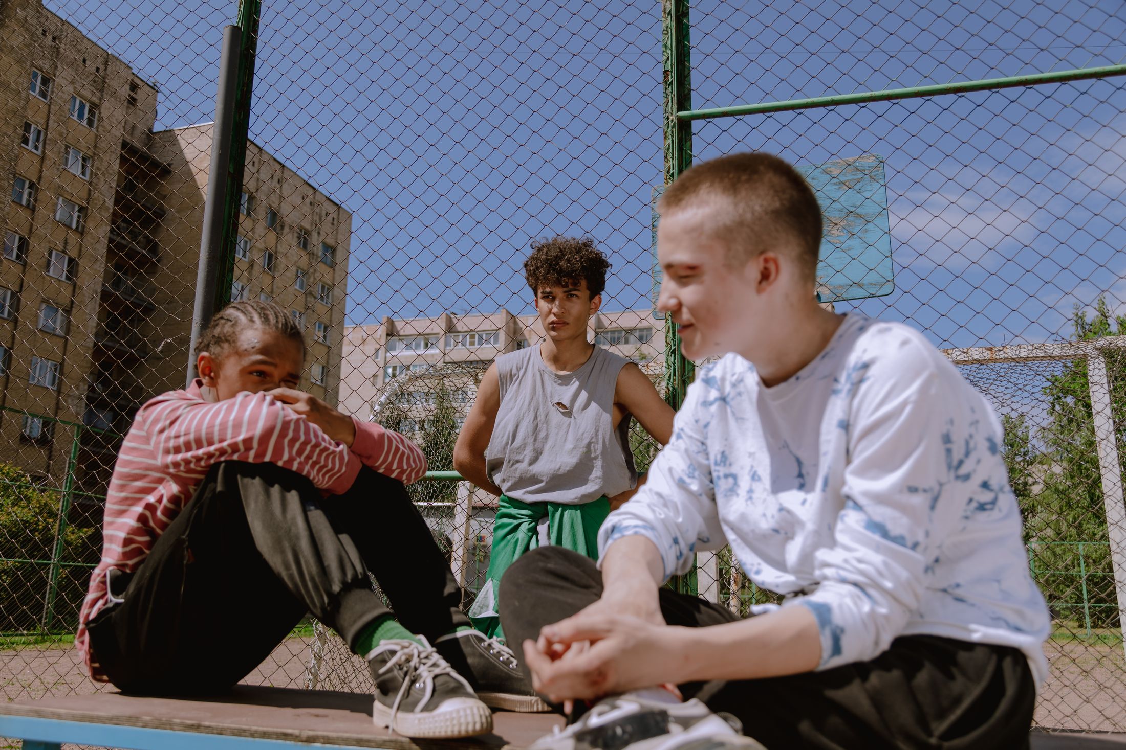Friends spending time together beside a basketball court — illustrative stock photograph, not a featured club