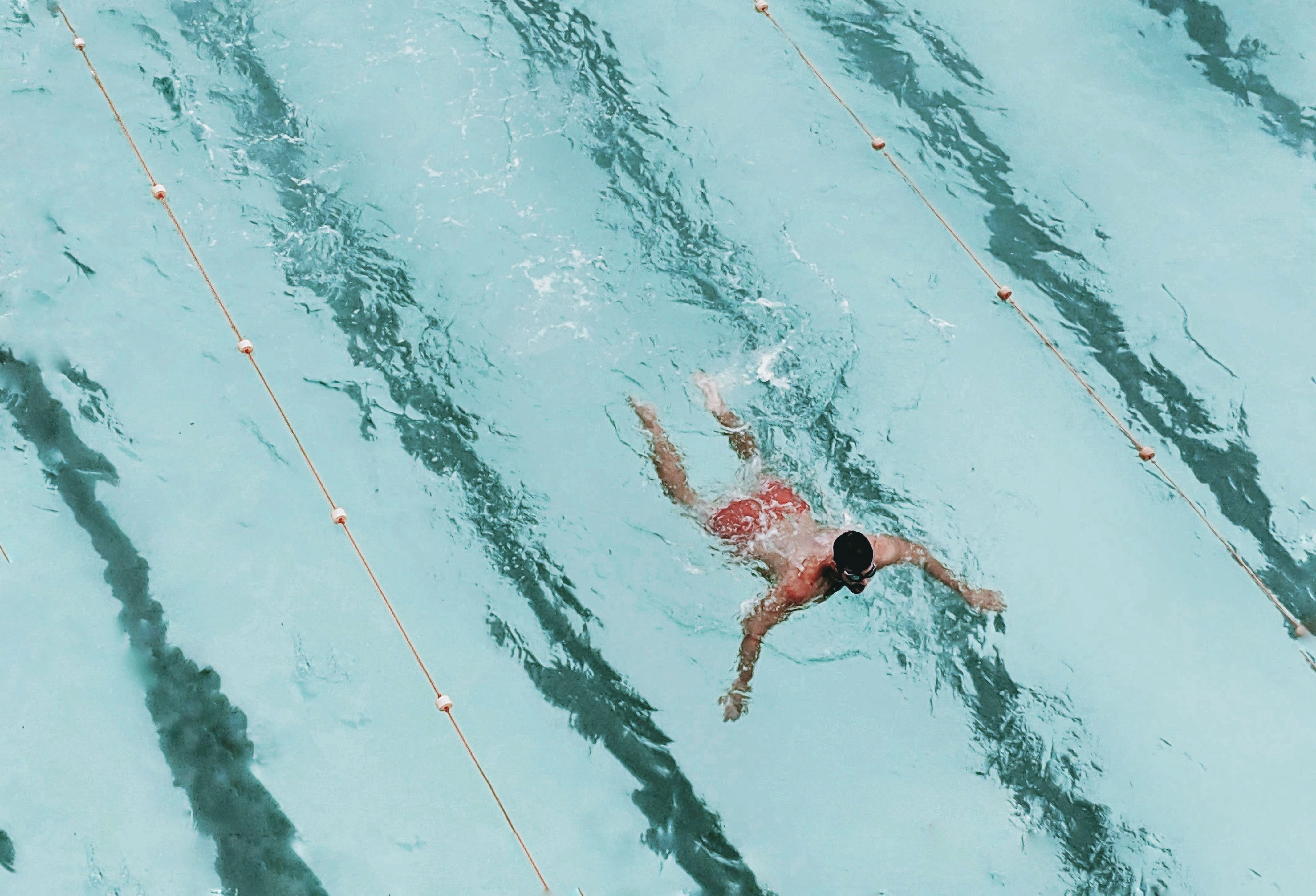 Swimmer seen from above in a sunlit pool